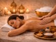 Woman receiving a relaxing back massage on a marble bed in a traditional Moroccan hammam with candles and spa elements at Villa 8 Ladies Salon and Spa Dubai.